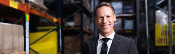 happy middle aged businessman in suit smiling in warehouse, professional headshot banner - Photo, Image