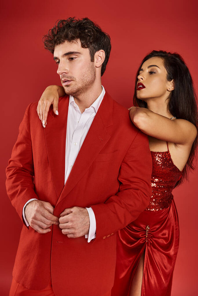 Çekici, kırmızı dudaklı genç bir kadın Sevgililer Günü 'nde takım elbiseli yakışıklı bir adamın omzuna yaslanıyor. - Fotoğraf, Görsel