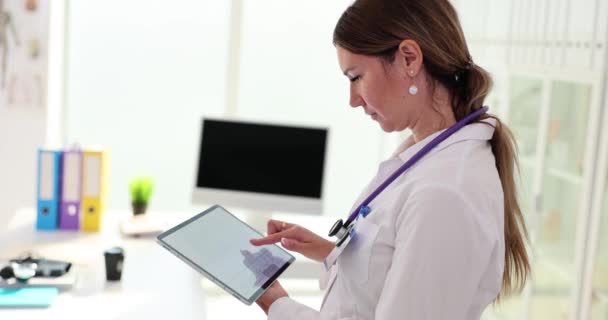Digitales Tablet mit Elektrokardiogramm in den Händen des Kardiologen. EKG-Diagnose von Rhythmusstörungen - Filmmaterial, Video