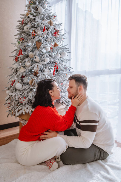 красивая пара возле рождественской елки дома - Фото, изображение
