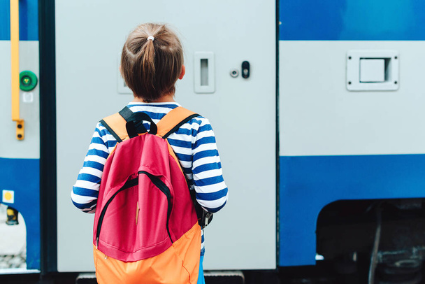 Niño esperando el tren expreso en la plataforma de la estación de tren. Un chico con mochila en un metro. Viajes, turismo, vacaciones y concepto familiar. - Foto, imagen