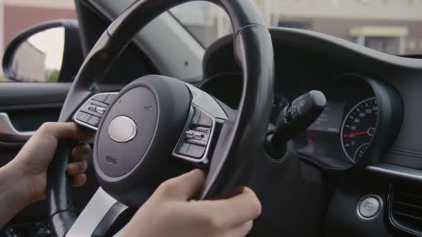 Nahaufnahme eines unkenntlich gemachten Fahrers, der während der Fahrt mit einem Auto im Stadtgebiet am Lenkrad dreht - Filmmaterial, Video