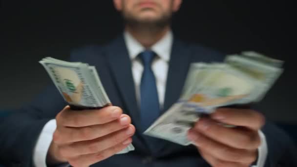 Formálně oblečený muž počítající dolarové bankovky, detailní záběr. Koncept investic, úspěchu, finančních vyhlídek nebo kariérního postupu. - Záběry, video