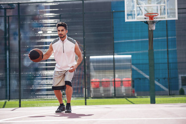 Красивий баскетболіст грає на баскетбольному майданчику на відкритому повітрі
 - Фото, зображення
