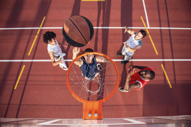Vue du dessus des beaux joueurs de basket-ball jouant sur le terrain de basket en plein air
 - Photo, image
