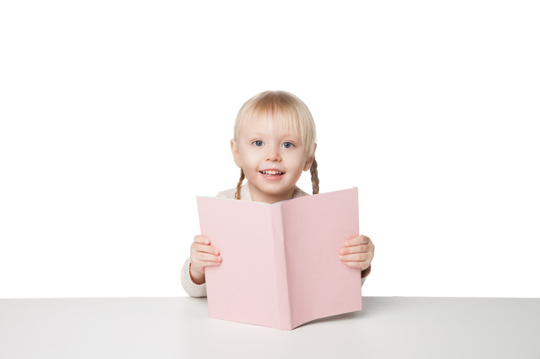 Söpö, iloinen tyttö lukemassa kirjaa. Eristetty valkoisella pohjalla
 - Valokuva, kuva