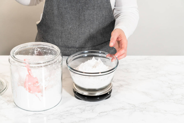 Dla domowej roboty lukier z serem kremowym, dokładny pomiar cukru pudru jest niezbędny, zapewniając idealną równowagę słodkości i kremowej konsystencji. - Zdjęcie, obraz