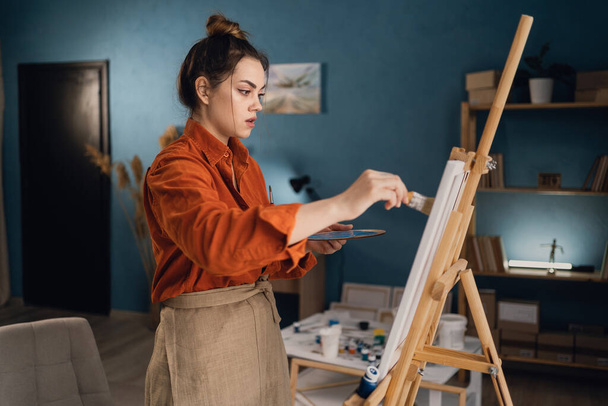 Творча латинська художниця, яка стоїть на новій картині. Щаслива молода леді, яка малює на полотні у своїй художній студії. Художник працює у своїй домашній майстерні. Копіювати простір - Фото, зображення