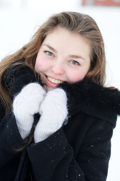 Young pretty woman warming with gloves and coat in winter - Фото, зображення