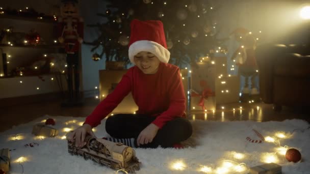 A gyerek a karácsonyi ajándékával játszik. .  - Felvétel, videó