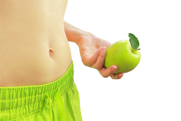 Женщина держит зеленое яблоко рядом с ее здоровый живот, изолированный на белом
 - Фото, изображение