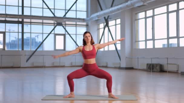 chica muscular en ropa deportiva roja haciendo el popular ejercicio Side Bend  - Metraje, vídeo