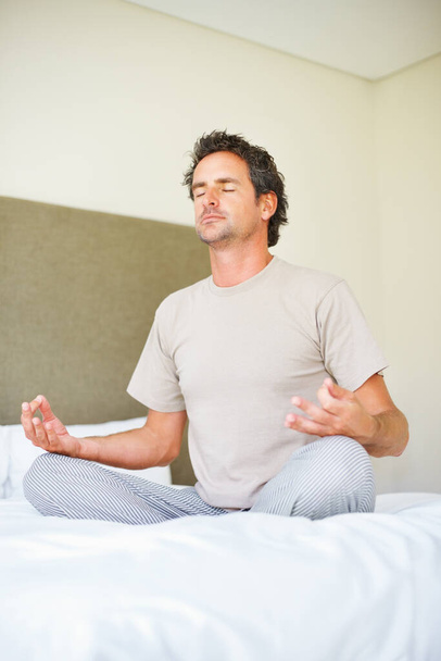 Lotosowe ręce, pozycja do jogi i mężczyzna na łóżku z medytacją, spokojem i zdrowiem psychicznym w swoim domu. Oddychanie, równowaga i mężczyzna zrelaksować się w sypialni z duchowej, uzdrawiania lub holistycznej opieki własnej. - Zdjęcie, obraz