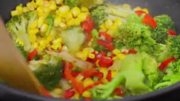 Готовим разноцветную жареную картошку со свежими овощами и деревянной ложкой - Кадры, видео