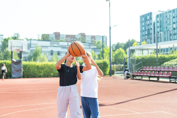 Adolescente menina jogador de basquete de rua com bola no campo de basquete da cidade ao ar livre. Foto de alta qualidade - Foto, Imagem