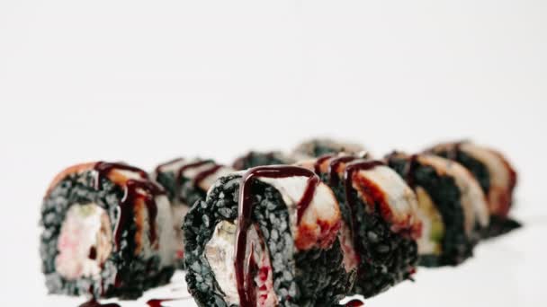 黒米ウナギのロールアップが美しいブループレートのアンギソースで乾燥 寿司とアジア料理のコンセプト愛 - 映像、動画