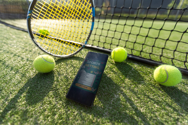Vista de alto ângulo do telefone móvel com equipamento de tênis em fundo preto. Foto de alta qualidade - Foto, Imagem
