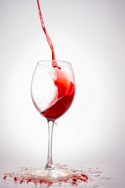 Verre de vin rouge avec éclaboussures sur blanc. - Photo, image