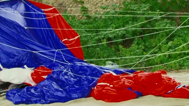 Tuch aus blauem und rotem Fallschirm schwankt im Wind - Filmmaterial, Video