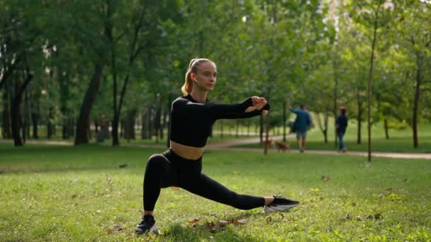Sportovní dívka během ranního cvičení na čerstvém vzduchu dělá nohy strečink sportovní zdravotní cvičení - Záběry, video