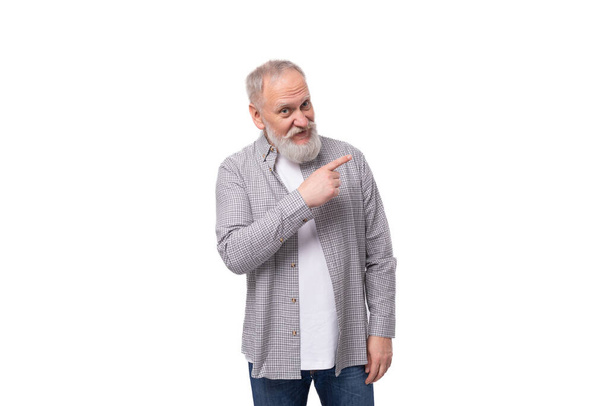 όμορφος αστείος γκριζομάλλης ηλικιωμένος άνδρας με γενειάδα και μουστάκι σε καρό πουκάμισο σε λευκό φόντο με χώρο αντιγραφής. - Φωτογραφία, εικόνα