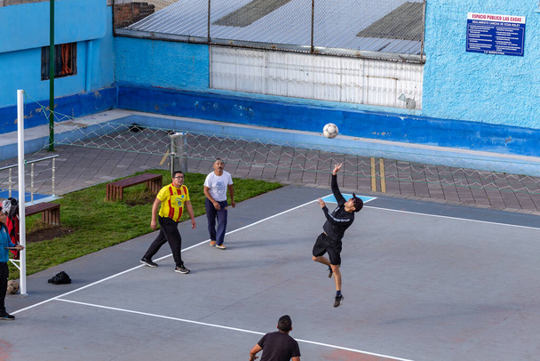 Кито, Эквадор, 3 июня 2023 года: Жители района Лас-Касас проводят свободное время, играя в экваволи, форму волейбола, который играет неформально между тремя людьми с каждой стороны в городских парках. - Фото, изображение