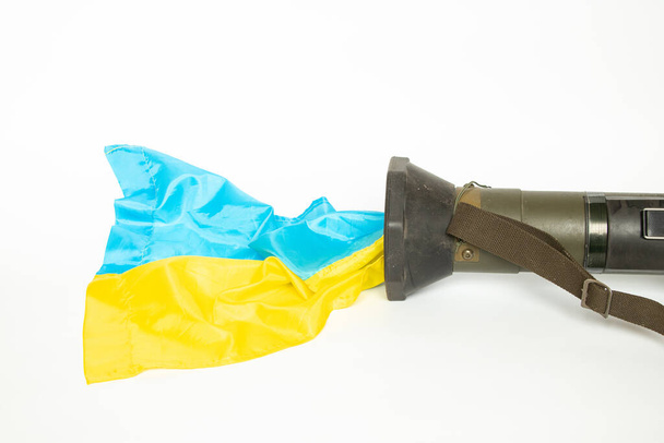 Εκτοξευτής χειροβομβίδων και σημαία της Ουκρανίας, που χρησιμοποιείται στον πόλεμο στην Ουκρανία, σε λευκό φόντο, αντιαρματικό όπλο, εκτοξευτής χειροβομβίδων μάχης, πολεμικό και στρατιωτικό όπλο - Φωτογραφία, εικόνα