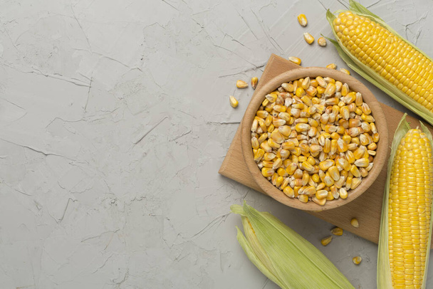 Dry corn with fresh cobs on concrete background, top view - Photo, Image