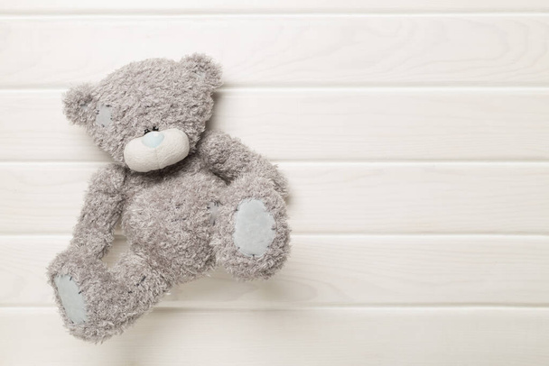 Cute teddy bear on wooden background, top view - Φωτογραφία, εικόνα