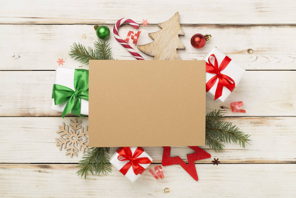 Ευχετήρια κάρτα mockup με χριστουγεννιάτικη διακόσμηση σε ξύλινο φόντο, top view - Φωτογραφία, εικόνα