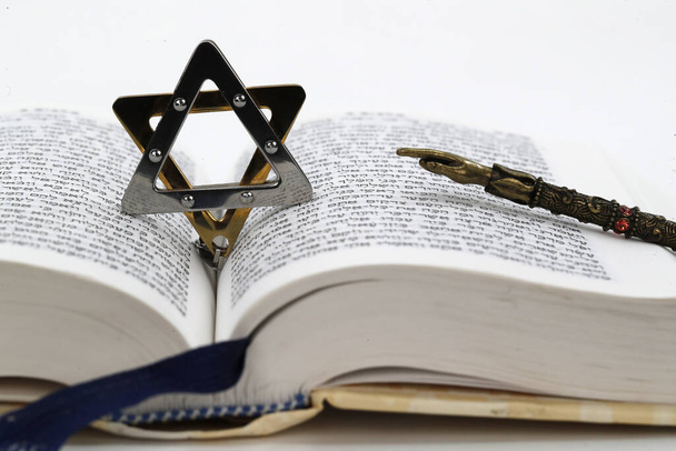 Détail en gros plan d'une Torah en hébreu, d'une étoile de David et d'un yad. Symboles juifs. - Photo, image
