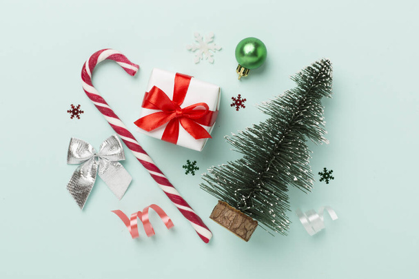 Μινιατούρα χριστουγεννιάτικο δέντρο με κουτί δώρου και διακόσμηση στο φόντο χρώμα - Φωτογραφία, εικόνα