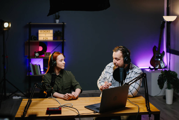Egy online blogger podcast epizódot forgat egy vendéggel a stúdióban. A tartalomkészítő élő beszélgetést közvetít a közösségi oldalakon. Rádióműsorok élő adás közben a stúdióban. - Fotó, kép