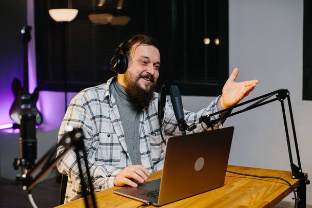 Un bloguero en línea habla en un micrófono durante una transmisión. Presentador de radio en el estudio durante la emisión. - Foto, Imagen