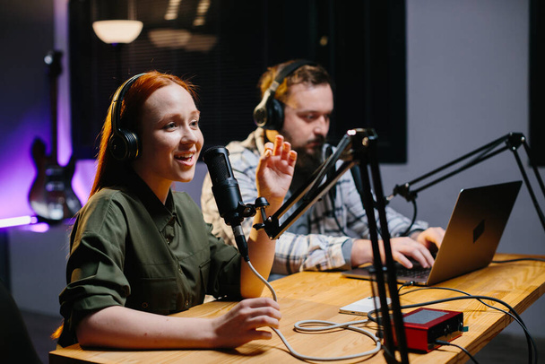 два радиоведущих в наушниках смеялись во время записи подкаста в студии - Фото, изображение