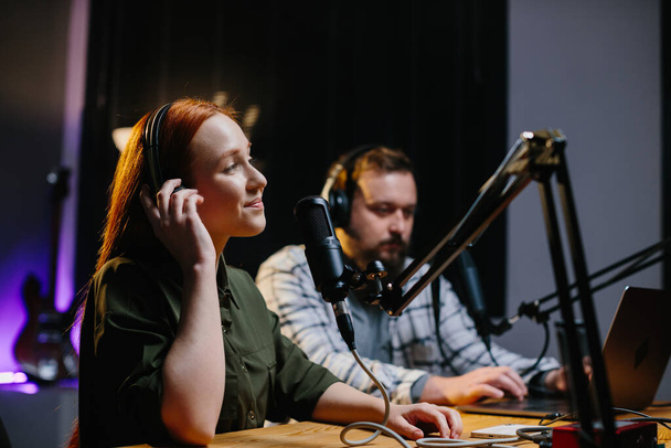Junge Radiomoderatorin live mit ihrem Kollegen. Gastgeber arbeiten am Radio. - Foto, Bild