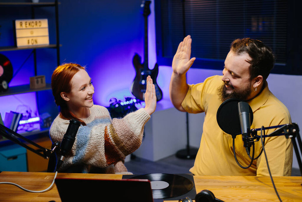 Man having conversation with woman in internet broadcast using professional microphone and audio mixer. Online radio station host recording podcast interviewing guest in late night talk show. - Photo, image