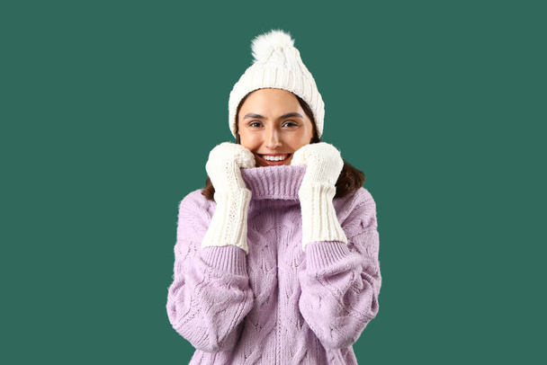 Mladá žena v zimě oblečení na zeleném pozadí - Fotografie, Obrázek