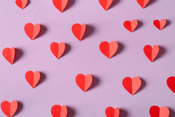 Composición con corazones de papel rojo sobre fondo rosa. Celebración de San Valentín - Foto, imagen