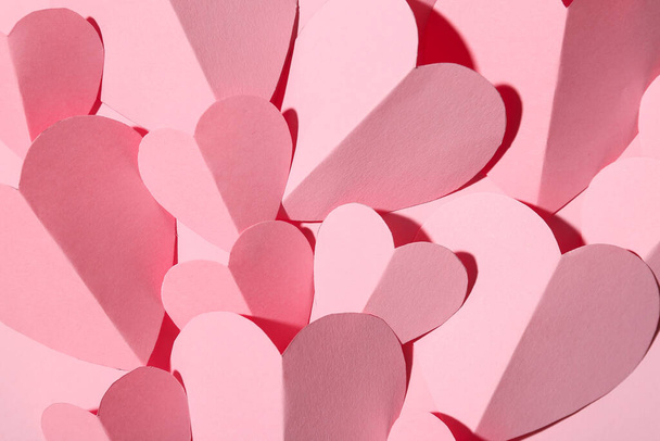 Corazones de papel rosa como fondo, primer plano. Celebración de San Valentín - Foto, imagen