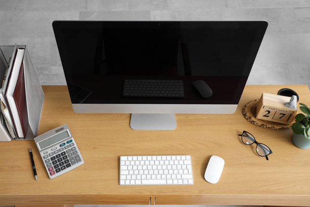 Blank monitor komputerowy z kalkulatorem na stole w biurze, widok z góry - Zdjęcie, obraz