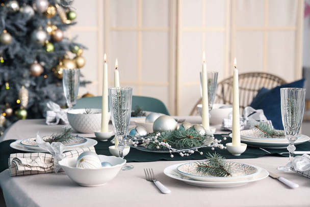 Красива обстановка столу з палаючими свічками та різдвяними прикрасами в їдальні, крупним планом - Фото, зображення
