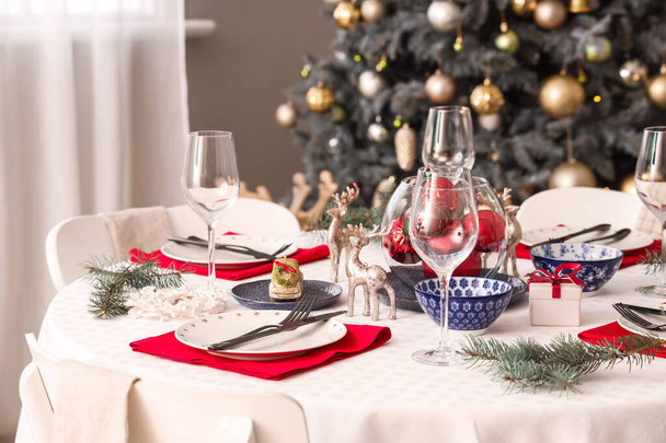 Накрытие праздничного стола с бокалами вина и рождественскими украшениями, крупным планом - Фото, изображение