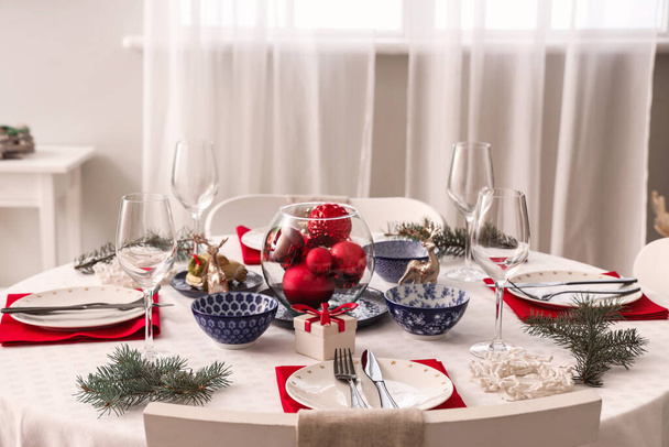ダイニングルームでワイングラスとクリスマスの装飾でお祝いのテーブルの設定 - 写真・画像