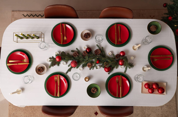 Εορταστική ρύθμιση τραπεζιού με χριστουγεννιάτικα στολίδια και κεριά που καίγονται, κορυφαία προβολή - Φωτογραφία, εικόνα