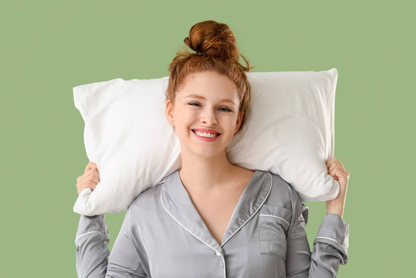 Šťastná mladá žena s bílým měkkým polštářem na zeleném pozadí - Fotografie, Obrázek
