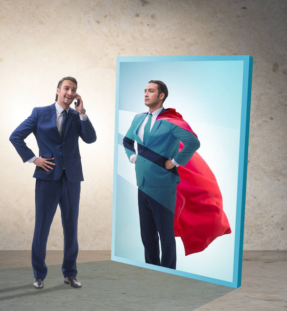 Ο επιχειρηματίας βλέπει τον εαυτό του στον καθρέφτη ως υπερήρωα. - Φωτογραφία, εικόνα