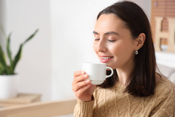 Mulher bonita bebendo café fresco na sala de estar, close-up - Foto, Imagem