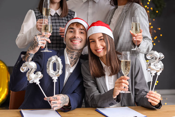 Nuoret kollegat kuva 2024 ja samppanjaa juhlii uutta vuotta yritysjuhlissa toimistossa - Valokuva, kuva