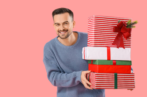 bel homme avec des cadeaux de Noël sur fond rose - Photo, image